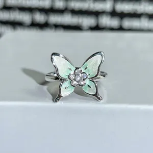 Detailed shot of a green enamel butterfly zircon open ring, dainty floral jewelry for women.