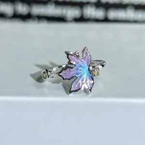 Detailed close-up view of the sterling silver open ring with purple enamel maple leaf and zirconia.