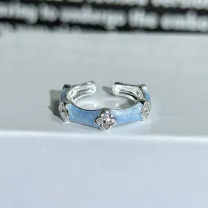 Detailed view of light blue enamel four-leaf clover ring with sparkling zirconia stones.