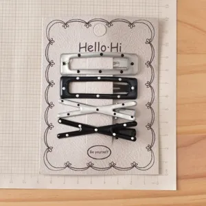 Detailed view of Y2K sweet and cool black and silver polka dot hair clips set on display card.