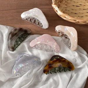Vue détaillée de pinces à cheveux triangulaires en acétate irisé coloré pour cheveux épais.