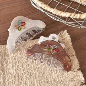 Primo piano di eleganti mollette per capelli in acrilico con colorati fiori di strass.
