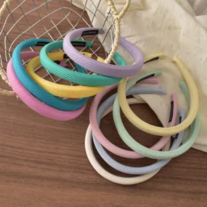 Detailed view of colorful striped sponge headbands in pastel shades, ideal hair accessories.