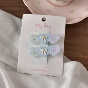Primo piano molto dettagliato delle mollette per capelli a cuore con fiocco e strass.