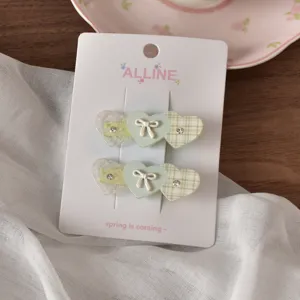 Primo piano dettagliato della molletta per capelli a cuore con motivo a quadri e strass.