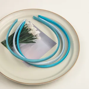 Vue détaillée de fins serres-tête en satin aux tons bleus, accessoire capillaire élégant.