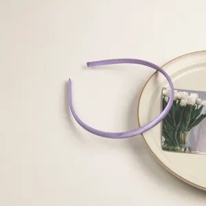 Détail de serre-tête fin en satin violet, design minimaliste élégant pour tous les jours.