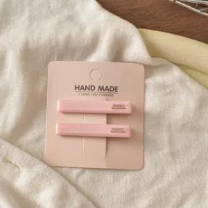 Detailansicht minimalistischer rosa Acetat-Haarspangen mit handgemachter Kartonage.