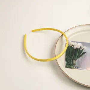 Serre-tête fin en satin jaune pour usage quotidien, surface lisse, accessoire élégant.