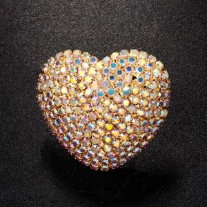 Gros plan d'un anneau de cœur en cristal étincelant avec des strass colorés et un anneau réglable.