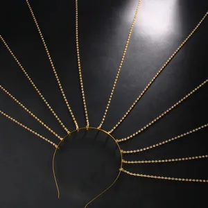 Diadema dorada de estrats con sol y largas cadenas de borlas de cristal para fiesta elegante.