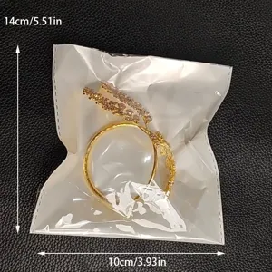 Detailansicht des goldenen Strass offenen Armreifs in einer klaren Schutzverpackung.