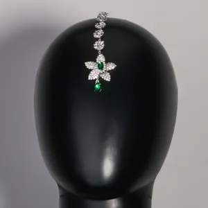 Vue détaillée d'une chaîne de front indienne en cristal avec strass verts et motif floral.