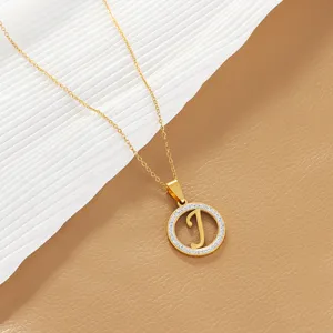 Gold-plated initial J pendant necklace with sparkling crystal halo detail close up.