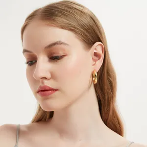 Elegant gold hoop earrings detail shot, minimalist fashion metal jewelry for women daily wear.