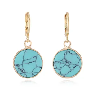 Detailed view of vintage turquoise round earrings with gold metal rim and lever back.