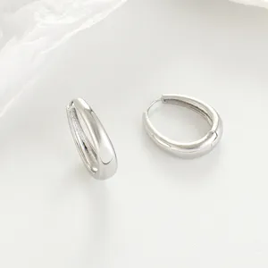 Close-up view of minimalist silver hoop earrings with a sleek polished metal design.