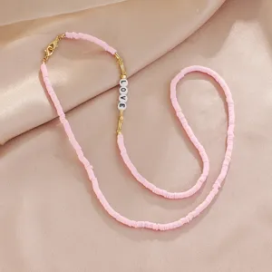 Pink heishi clay bead necklace detail featuring gold accents and cute LOVE letter beads.