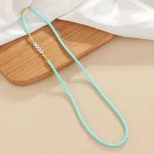 Turquoise heishi disk bead necklace with LOVE letter charms, detailed product view.