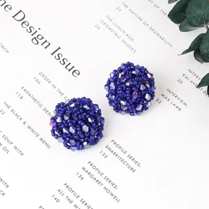 Gros plan détaillé de boucles d'oreilles boules perlées en perles bleu foncé élégantes.