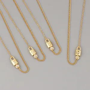 Gold plated letter lock pendant necklace detail, showcasing sparkling zircon inlaid initial charms.