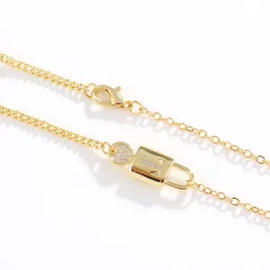 Close-up detail of a gold-plated initial lock pendant necklace with sparkling cubic zirconia stones.