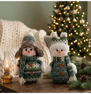 Gedetailleerde opname van gebreide sneeuwpop pluche poppen met gezellige kerstdecoratie.