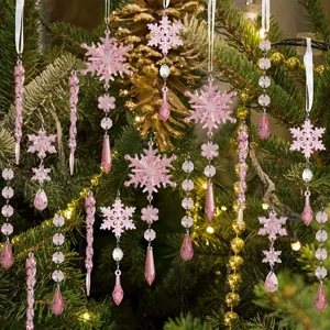 Vue détaillée de décorations de sapin en acrylique rose, flocons et pendentifs glaçons.