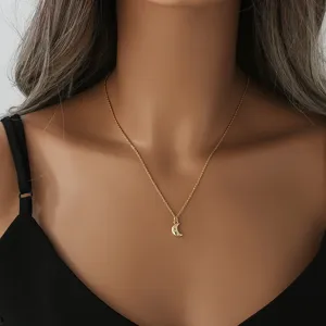 Zarte vergoldete Kette mit funkelndem Kristall-Mondsichel-Anhänger im feinen Detail-Look.