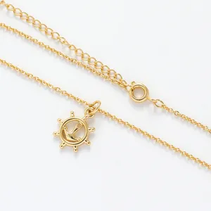 Detaillierte Nahaufnahme der mehrlagigen goldenen Kette mit maritimem Anker Anhaenger.