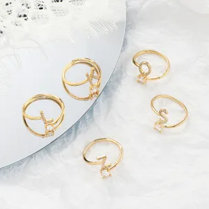 Vergoldete Buchstabenringe mit einzelnem Zirkonia, personalisierter Schmuck Detail.