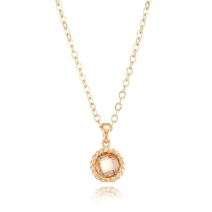 Close-up detail of the gold-tone chain necklace featuring a sparkling faceted champagne zircon pendant.