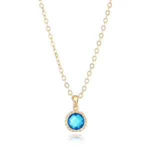Detailed close-up view of the gold-plated chain necklace with blue gemstone pendant.