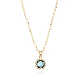 Detailed view of a gold-plated necklace featuring a blue faceted gemstone pendant and fine chain.