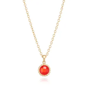 Close-up of gold-plated chain necklace featuring a red faceted birthstone pendant with twisted rim.