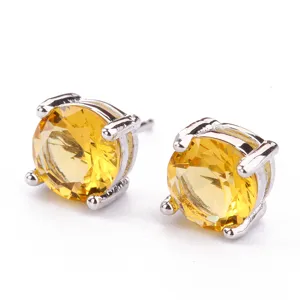 Primo piano di orecchini a lobo con zircone giallo rotondo e montatura a quattro griffe.