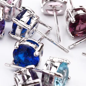Primo piano dettagliato di orecchini a lobo in argento sterling con zirconi colorati.