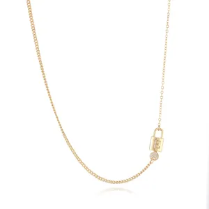 Close-up detail of gold plated necklace with lock and key pendant and zircon letter E.