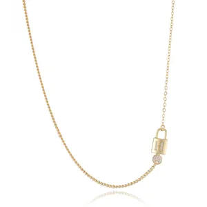 Close up detail of gold plated necklace with H letter zircon padlock pendant and key charm.