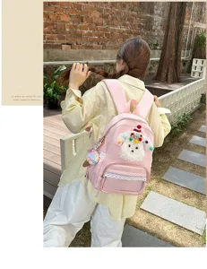 Sac à dos rose mignon avec bordure en dentelle et pendentif en peluche pour école.