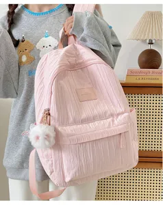 Vue détaillée du sac à dos scolaire plissé rose avec joli pendentif chat duveteux pour étudiants.