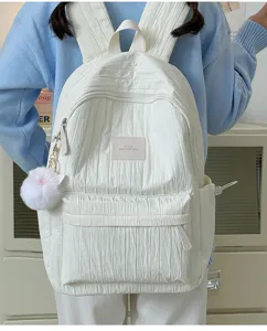 Vue détaillée du sac à dos uni plissé doux, joli pendentif boule en peluche pour le collège.