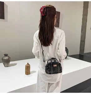 Black washed denim cross-body shoulder bag detail view, casual small handbag for daily use.