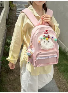 Détail de sac à dos rose avec adorable poupée chiot pelucheuse et belle bordure en dentelle.