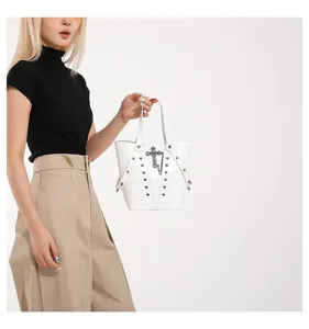 Bolso tipo cubo blanco de estilo punk con detalles de cruz metálica y tachuelas.