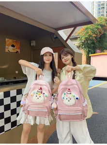 Détail de sac à dos rose avec adorable peluche de chiot moelleux et bordure en dentelle.