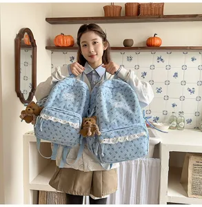 Korean style corduroy backpack detail view, cute bow print and lace trim with plush bear pendant.
