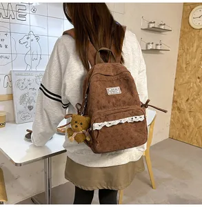 Details view of Korean style brown corduroy backpack with cute lace trim and bear pendant.