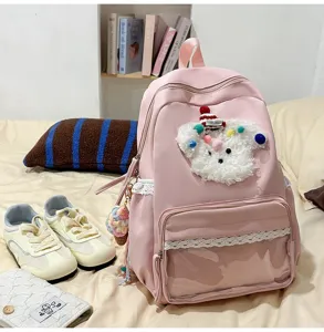 Détail de sac à dos rose avec peluche de chiot duveteuse, bordure en dentelle et poche avant.