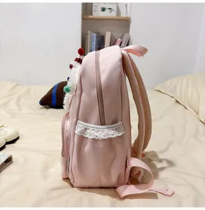 Vue détaillée de sac à dos rose avec décor en peluche et bordure en dentelle blanche.